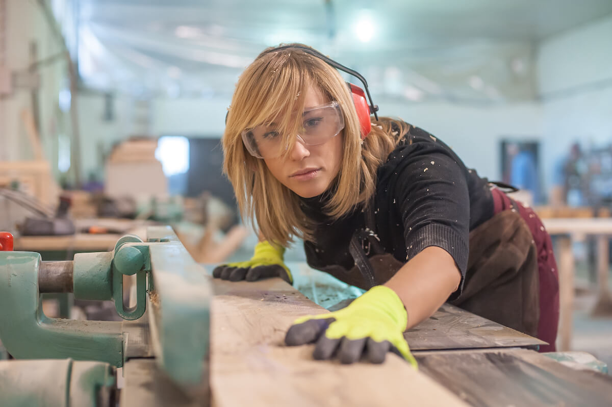 Female carpenter using electric sander