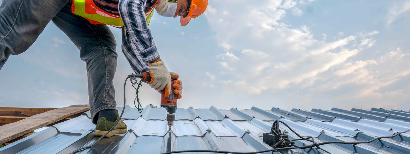 roofer drilling metal roof