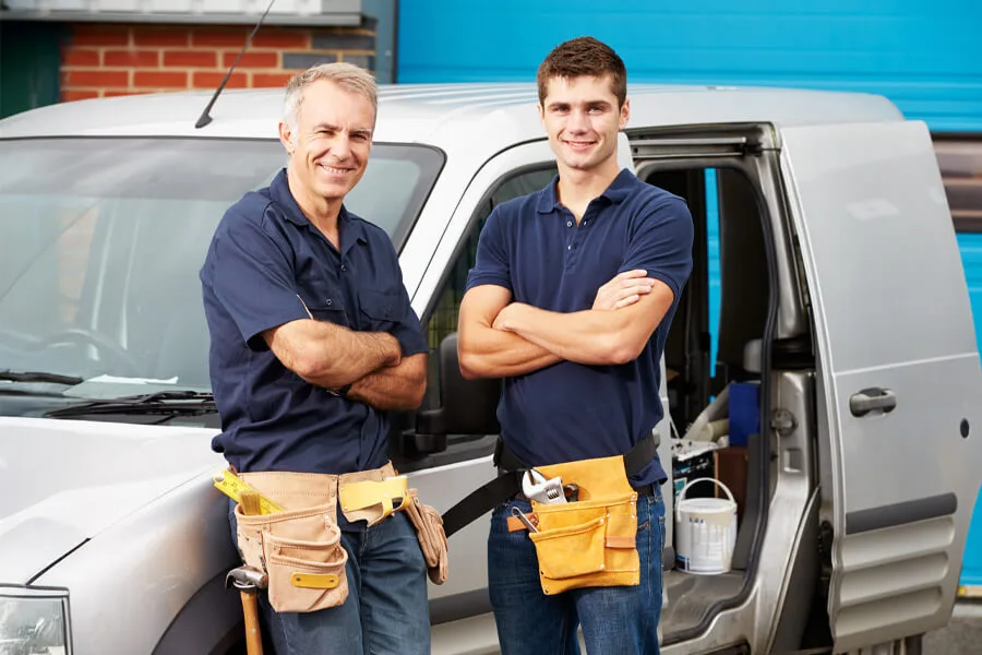 Image of 2 builders front facing with workvan behind