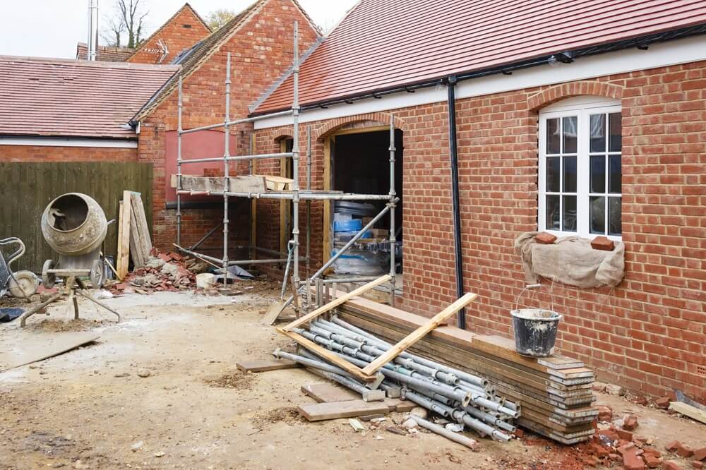 Finished brick exterior on a residential property with scaffolding and building tools still on site