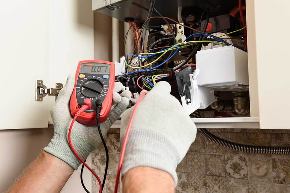 Gas engineer performing an electrical test on a modern boiler, representing the skilled work that benefits from targeted gas engineers marketing to attract local customers.