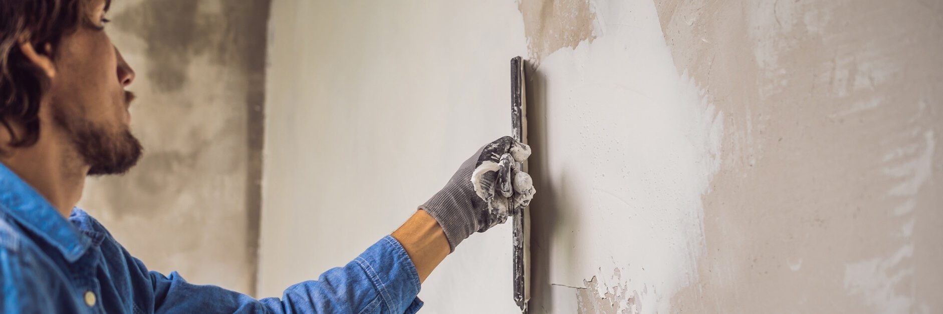 Professional plasterer applying a smooth plaster coat to an interior wall — a real example of the work marketing aims to promote.