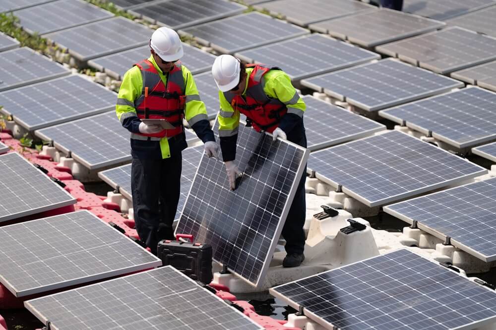 Two engineers inspecting floating solar panel units during a commercial installation.