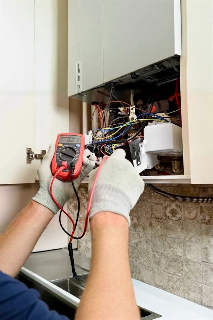 Gas engineer performing an electrical test on a modern boiler, representing the skilled work that benefits from targeted gas engineers marketing to attract local customers.