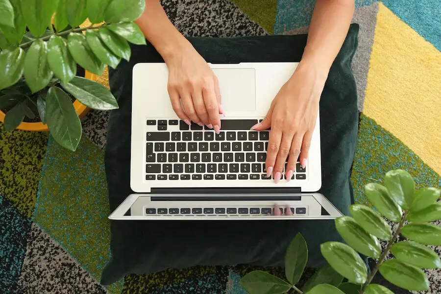 Hands typing on a laptop surrounded by green plants, representing TradePal’s digital marketing and SEO services for tradespeople.