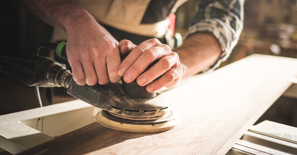 Trades marketing services showing a tradesperson sanding wood, representing professional craftsmanship and marketing support for builders and woodworking businesses.